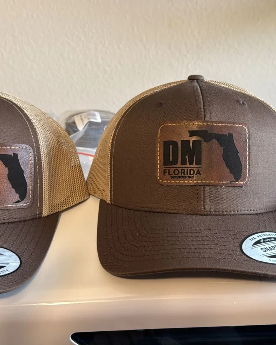 Brown trucker hats with laser-engraved DM Florida leather patches