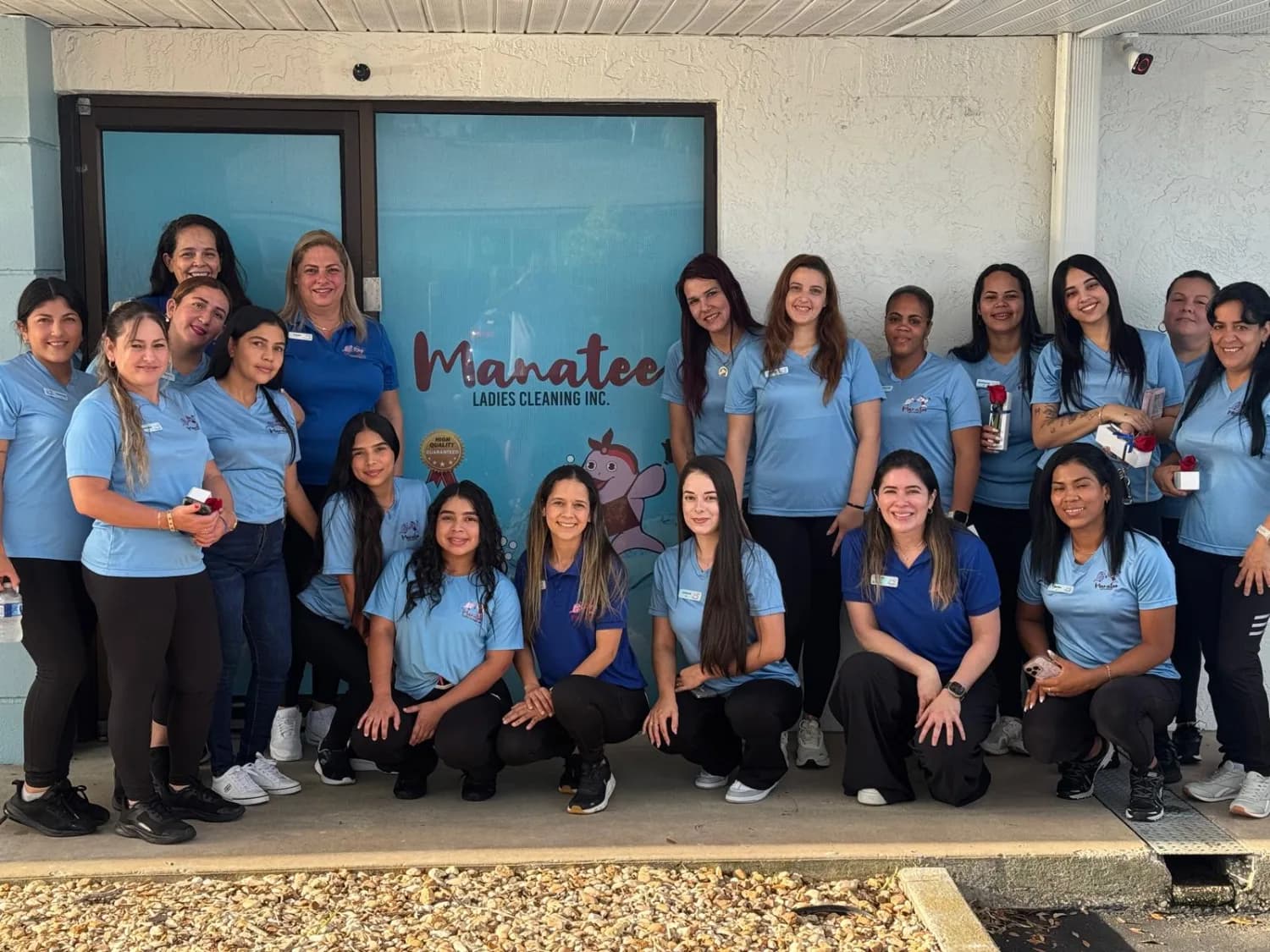 The Manatee Ladies Cleaning team in light blue uniform shirts in front of their office